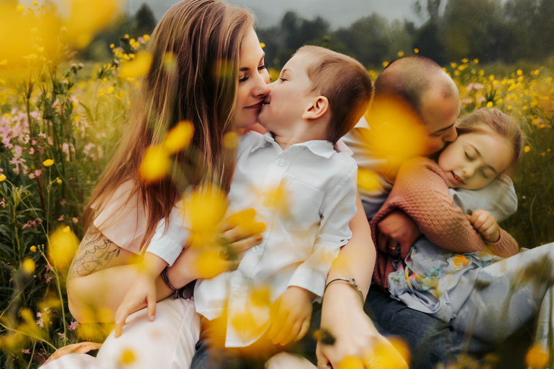 Family Photography, Family sitting in yellow flower field, toddler kissing mama